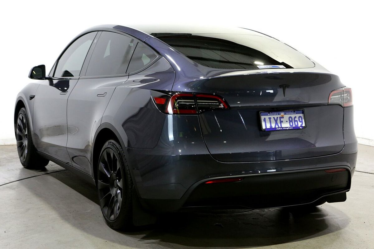 Tesla Model Y 2024 RWD Standard Range — Rear three-quarter · original lamps